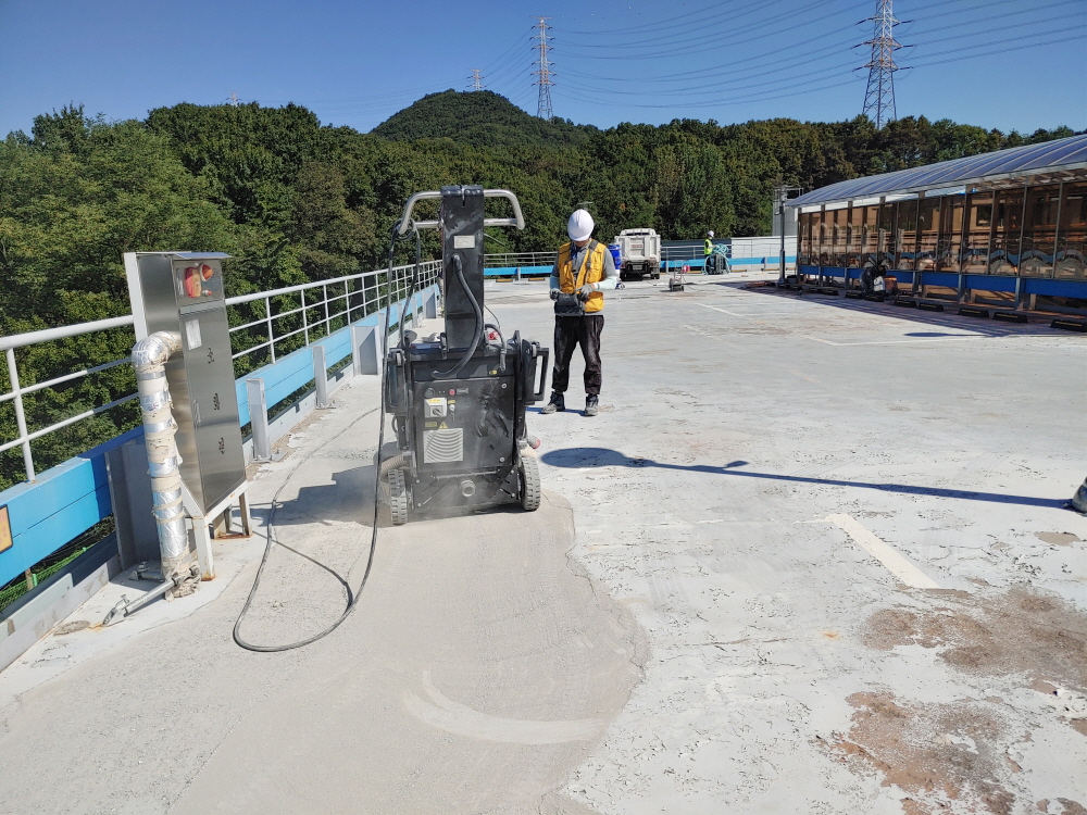 현장에서 공사 작업이 진행 중인 모습입니다. (개요, 비용을) · 자연광이 어우러져 콘크리트의 고급스러운 질감이 드러납니다.